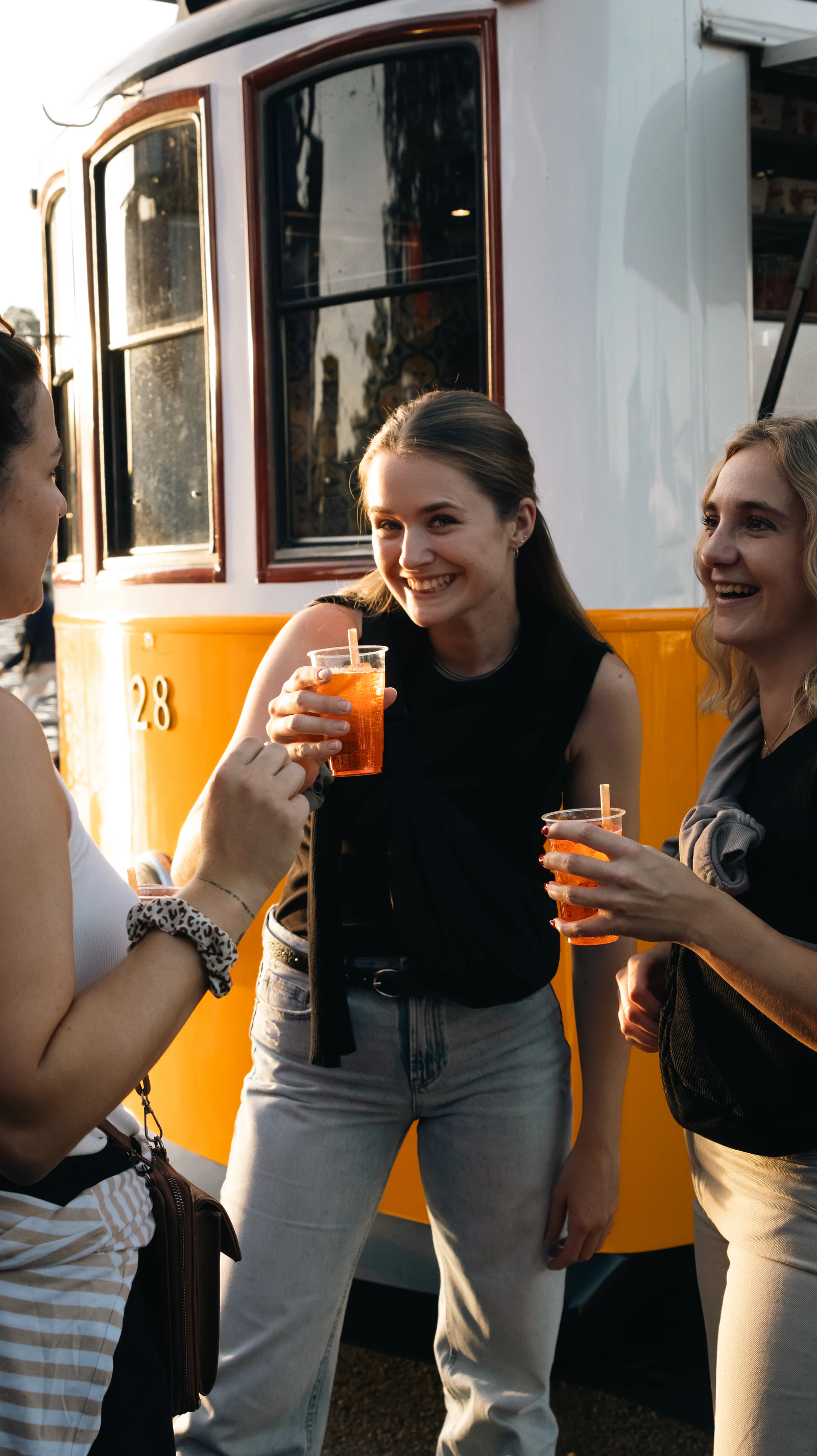 Des visiteurs, spritz à la main, à côté du tram-bar
