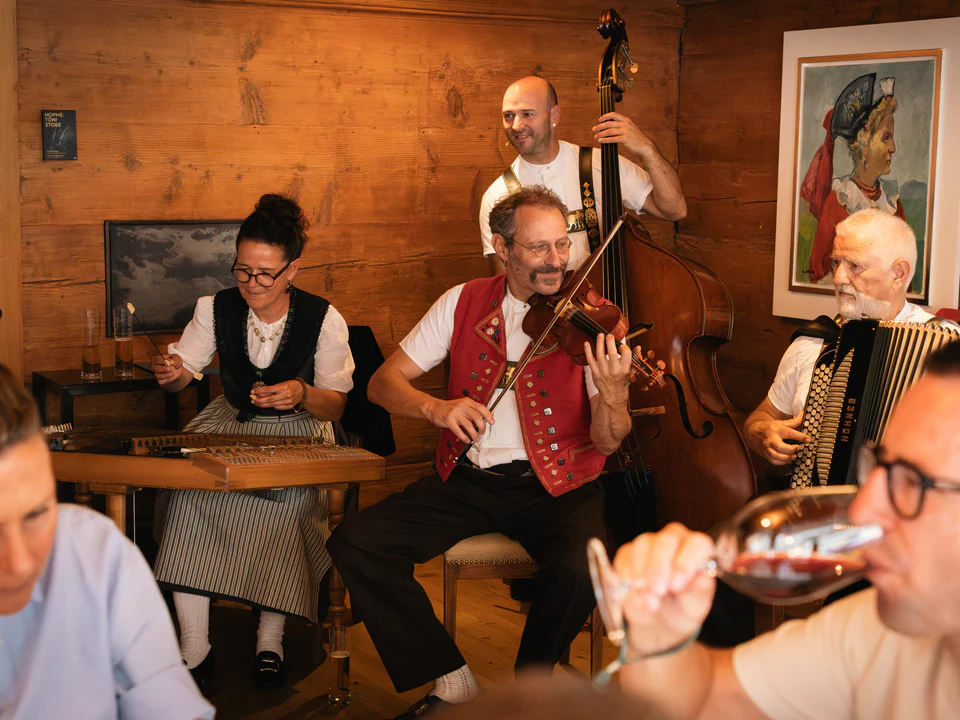 Die Volksmusikgruppe spielt für Gäste rund um einen Tisch